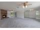 Open living space with a brick fireplace, ceiling fans, and access to the kitchen at 10980 Sw 62Nd Ave, Ocala, FL 34476