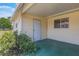 Covered patio area with an entry door with surrounding greenery and a view of the backyard at 10980 Sw 62Nd Ave, Ocala, FL 34476