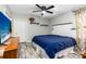 Bedroom with ceiling fan, TV, wood-look floors, and white headboard at 1101 Mizell Rd, Leesburg, FL 34748