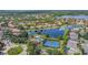 An aerial view showcases the community's pool, tennis courts, landscaping, and proximity to a lake at 11556 Via Lucerna Cir, Windermere, FL 34786