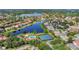 An aerial view shows a community with a pool, tennis courts, landscaping, and a large lake at 11556 Via Lucerna Cir, Windermere, FL 34786