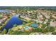 The community with a pool, tennis courts, and landscaping is showcased in this aerial view near a large lake at 11556 Via Lucerna Cir, Windermere, FL 34786