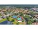 Aerial view of community featuring a pool, tennis courts, and lush landscaping near a scenic pond at 11556 Via Lucerna Cir, Windermere, FL 34786