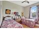 Comfortable bedroom with two twin beds, floral bedding, and a bright window at 11556 Via Lucerna Cir, Windermere, FL 34786