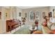Cozy living room featuring a piano, elegant seating, and two stained-glass windows at 11556 Via Lucerna Cir, Windermere, FL 34786