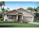 Charming single-story home featuring a classic design, a two-car garage, and a well-manicured lawn at 13216 Pergola Ave, Orlando, FL 32832
