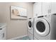 Convenient laundry room features new washer and dryer with white shaker cabinets at 13216 Pergola Ave, Orlando, FL 32832