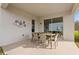Relaxing covered patio with dining table and chairs, perfect for outdoor entertaining with easy access to the indoors at 13216 Pergola Ave, Orlando, FL 32832
