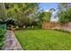 Well-manicured backyard features a lush lawn, privacy fence, bamboo, and a serene landscape for relaxation at 1632 Oriole Ave, Orlando, FL 32803