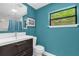 Bathroom featuring vibrant blue walls, a modern vanity, and a framed mirror at 1632 Oriole Ave, Orlando, FL 32803