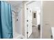 Bathroom showing a tiled shower with a blue curtain, plus access to the main bedroom at 1632 Oriole Ave, Orlando, FL 32803