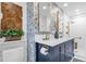 Stylish bathroom features a navy vanity, marble countertop, patterned wallpaper, and a walk-in shower with bronze fixtures at 1632 Oriole Ave, Orlando, FL 32803