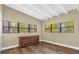 Bright bedroom showcases hardwood floors, exposed beam ceiling, and natural light from the large windows at 1632 Oriole Ave, Orlando, FL 32803