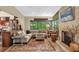 Comfortable living room boasts a stone fireplace, large windows with green outdoor views, and a cozy sectional sofa at 1632 Oriole Ave, Orlando, FL 32803