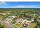 An aerial view of a residential area with mature trees, and multiple homes on large lots, under a blue sky at 1668 Spicewood Ln, Casselberry, FL 32707