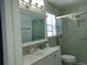 Bright bathroom with double sinks, vanity and tiled shower at 1668 Spicewood Ln, Casselberry, FL 32707