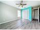 A cozy bedroom featuring a ceiling fan, wood floors, and a large closet at 1668 Spicewood Ln, Casselberry, FL 32707