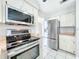 Updated kitchen with stainless steel appliances, white cabinets, and modern fixtures at 1668 Spicewood Ln, Casselberry, FL 32707