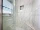 Modern tile shower with a glass door and built-in seat at 1668 Spicewood Ln, Casselberry, FL 32707