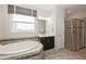 Primary bath with large soaking tub, glass enclosed shower, and window that provides natural light at 1757 Standing Rock Cir, Oakland, FL 34787