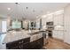 Bright kitchen features granite counters, stainless appliances, white cabinets, pendant lighting, and a view to living area at 1757 Standing Rock Cir, Oakland, FL 34787