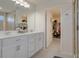 Bathroom featuring double sinks, quartz countertops, white cabinets, and a view into the walk-in closet at 178 Aria Way, Davenport, FL 33837