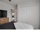 Bright bedroom featuring neutral walls, plush bedding, closet with doors, and a view into the adjacent room at 178 Aria Way, Davenport, FL 33837