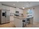 Modern kitchen featuring stainless steel appliances, granite countertops, white cabinets, and a central island with seating at 178 Aria Way, Davenport, FL 33837