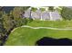 Overhead view capturing the residences, verdant lawns, and a winding path next to a peaceful pond at 21 Abbey Ct, Haines City, FL 33844