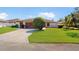 Charming single-story home with a well-manicured lawn, brick driveway, and an attached two-car garage at 21 Abbey Ct, Haines City, FL 33844