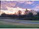 Picturesque view of a serene pond, lush green landscape, and a stunning sunset sky at 21 Abbey Ct, Haines City, FL 33844