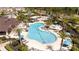 Aerial view of a community pool, splash pad, and clubhouse surrounded by lush landscaping at 2126 Ridge Pointe Ln, Clermont, FL 34715