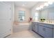 Elegant bathroom featuring a soaking tub, double vanity, and neutral tile at 2126 Ridge Pointe Ln, Clermont, FL 34715