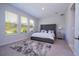 Spacious bedroom with a gray tufted headboard, plush rug, and plenty of natural light at 2126 Ridge Pointe Ln, Clermont, FL 34715