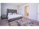 Bedroom featuring gray upholstered bed, mirrored nightstand, en-suite bathroom, and soft rug at 2126 Ridge Pointe Ln, Clermont, FL 34715