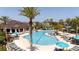 The community pool area features lounge chairs, umbrellas, and a covered pavilion, set against a backdrop of palm trees at 2126 Ridge Pointe Ln, Clermont, FL 34715