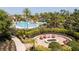 The pool area features a circular fire pit with seating, surrounded by lush landscaping and walkways at 2126 Ridge Pointe Ln, Clermont, FL 34715