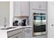 Close-up of modern kitchen with stainless steel appliances, sink, and gray cabinetry at 2126 Ridge Pointe Ln, Clermont, FL 34715