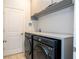 A modern laundry room featuring front load washer/dryer units and ample counter space at 2126 Ridge Pointe Ln, Clermont, FL 34715