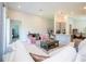 Open living room featuring a white sectional sofa, pink accent chairs, and modern decor at 2126 Ridge Pointe Ln, Clermont, FL 34715
