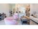 Bright living room showcasing pale, neutral walls and tile flooring, accentuated by pink chairs and a view to the kitchen at 2126 Ridge Pointe Ln, Clermont, FL 34715