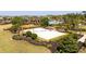 The sand volleyball court, with net in place, is surrounded by lush landscaping and overlooks a pool and playground at 2126 Ridge Pointe Ln, Clermont, FL 34715