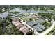 Community aerial featuring tennis courts, clubhouse, and a pool overlooking a lake and surrounding homes at 220 Wimbledon Cir, Lake Mary, FL 32746
