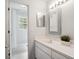 Bright bathroom featuring a white vanity with stone countertop and decorative framed mirror at 220 Wimbledon Cir, Lake Mary, FL 32746
