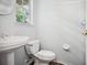 Powder room features a pedestal sink, toilet, neutral paint, and wood look floors at 220 Wimbledon Cir, Lake Mary, FL 32746