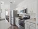 Bright kitchen features white cabinets, stainless steel appliances, and modern fixtures at 220 Wimbledon Cir, Lake Mary, FL 32746