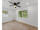 Bright bedroom with two windows, ceiling fan, and light wood-look flooring at 2205 Pine Island Dr, New Smyrna Beach, FL 32168
