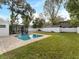 Inviting pool area with a screen enclosure and a well-maintained green lawn at 2205 Pine Island Dr, New Smyrna Beach, FL 32168