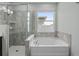 This bathroom features both a walk in shower with glass door and a tub at 2417 Annacella Ave, Kissimmee, FL 34741