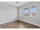 Neutral bedroom showcasing hardwood floors and natural light from three windows, creating a peaceful atmosphere at 2417 Annacella Ave, Kissimmee, FL 34741